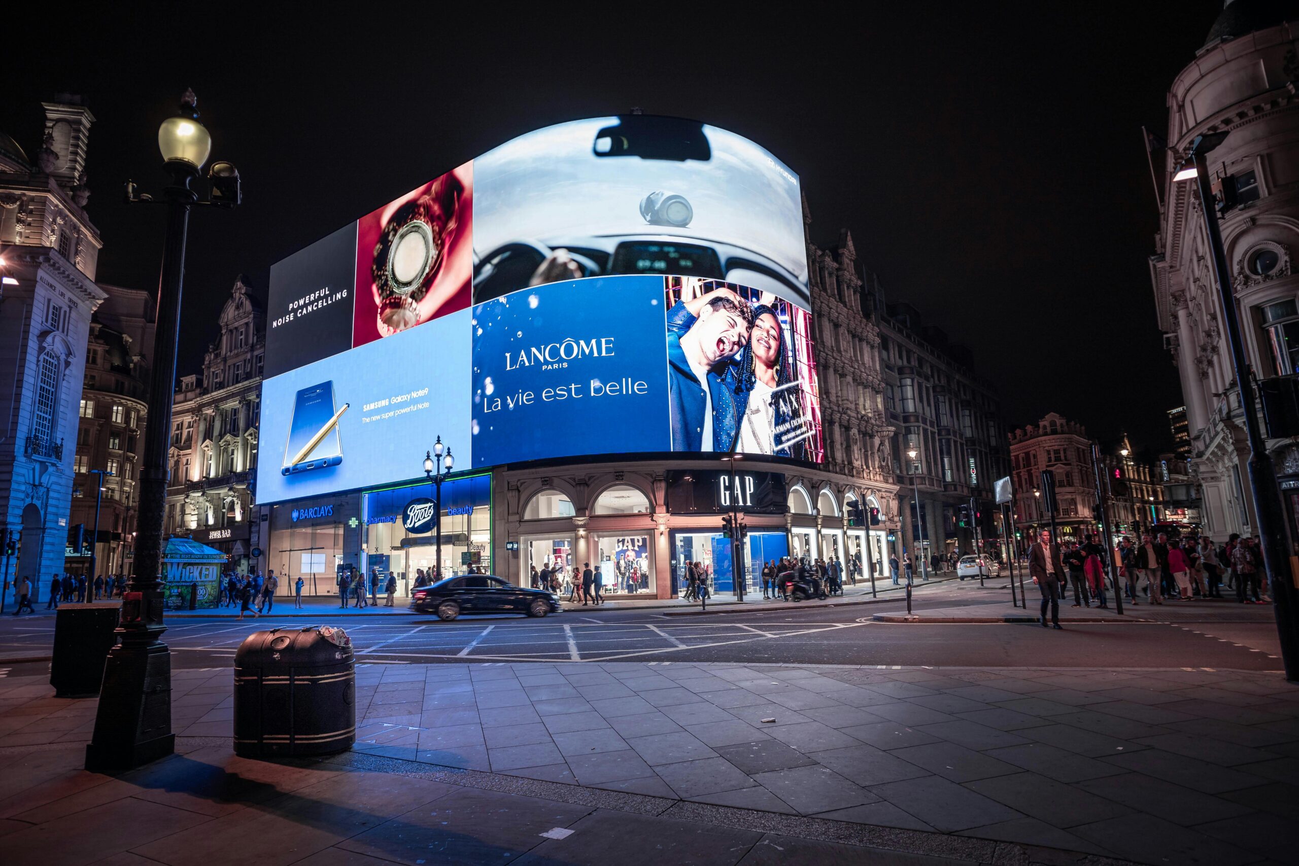 Night view of illuminated billboards at Piccadilly Circus, showcasing vibrant city life in London.